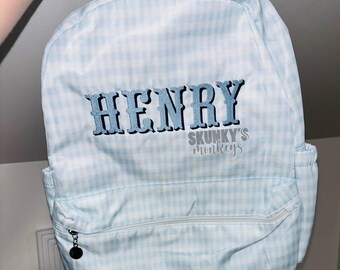 May include: A blue and white gingham backpack with the name "HENRY" and the text "SKUNKY'S monkeys" embroidered on the front.