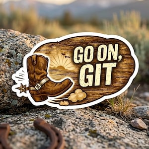 Puede incluir: Una pegatina con una bota de vaquero marrón y las palabras "GO ON, GIT" sobre un fondo de madera. El diseño incluye una puesta de sol, pájaros y una estrella. La pegatina está colocada sobre una roca.