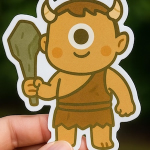 May include: A sticker featuring a cartoon cyclops character in shades of brown and tan, holding a club. The cyclops has a single eye, small horns, and is wearing a loincloth. The sticker has a white border.