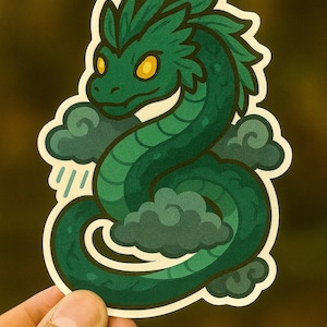 Può includere: Un adesivo verde raffigurante un'illustrazione stilizzata di un drago serpentino con occhi gialli, circondato da nuvole verde scuro e pioggia. Il drago è arrotolato, con un bordo bianco.