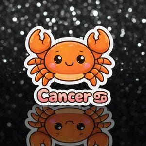 May include: A sticker depicting a cartoon crab in orange and peach hues. The crab has large eyes and a smiling expression. The word "Cancer" is written below in pink and white, along with the Cancer zodiac symbol.