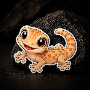 Op de afbeelding: Een sticker met een cartoongekko met een vriendelijke uitdrukking. De gekko heeft een lichtoranje lichaam met donkerdere oranje vlekken, grote bruine ogen en een rode mond. De sticker is wit omlijnd en geplaatst tegen een donkere, getextureerde achtergrond.