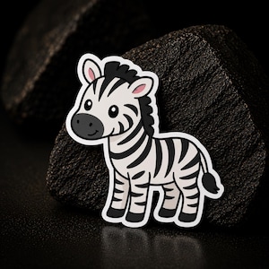 May include: A sticker featuring a cartoon zebra with a white body and black stripes, a black mane, and a black tail. The zebra has large black eyes, a dark gray muzzle, and pink inner ears, outlined in a thick white border for a clean appearance.