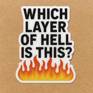 May include: A white sticker with black text that reads "WHICH LAYER OF HELL IS THIS?" The sticker has a flame design at the bottom in shades of orange and yellow.