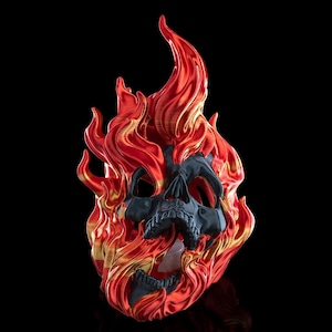 May include: A black skull sculpture engulfed in vibrant red and gold flames. The skull has detailed features and is set against a black background. The flames have a glossy finish, creating a striking visual effect.