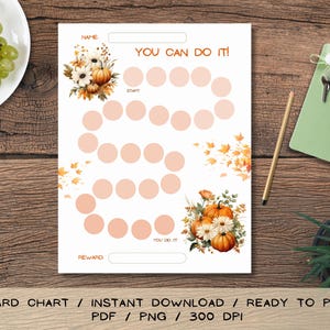 Op de afbeelding: Een witte beloningskaart met de tekst "YOU CAN DO IT!" en een reeks cirkels om de voortgang bij te houden. De kaart bevat illustraties van pompoenen en bloemen, met ruimte voor een naam en een beloning. De tekst "REWARD CHART" is zichtbaar.