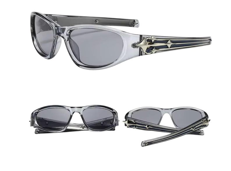 May include: Clear frame sunglasses with dark gray lenses and a silver and black decorative detail on the arms.