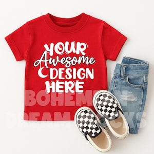 May include: Red short-sleeved t-shirt with the text "YOUR Awesome DESIGN HERE" in white. The t-shirt is paired with blue jeans and black and white checkered slip-on shoes.