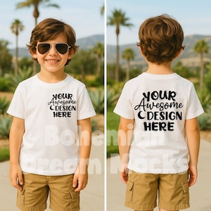 May include: White t-shirt mockup for kids with the text "YOUR AWESOME DESIGN HERE" on the front and back. The shirt is being worn by a child standing outdoors in front of a green background.