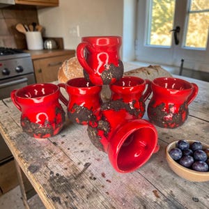 Peut inclure: Ensemble de trois tasses en céramique avec une finition mate et mouchetée. Les tasses sont dans des tons crème, gris clair et gris foncé. Chaque tasse a un design simple et minimaliste, parfait pour le café ou le thé.