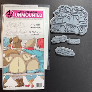 May include: A craft set featuring unmounted rubber stamps. The set includes a large stamp depicting three figures on a bench, and three smaller text stamps. The packaging shows a colourful illustration of the figures.