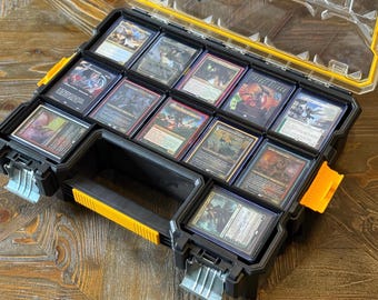 May include: A black and yellow plastic storage container filled with collectible trading cards. The container has a clear lid and a yellow handle. The cards are in protective sleeves and feature various fantasy art.