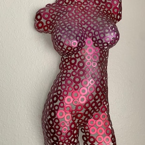 May include: A metal sculpture of a human torso made of hundreds of small, overlapping, metallic circles. The circles are a gradient of pink and red.