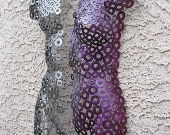 May include: Two metal sculptures of human torsos made from washers. The sculpture on the left is silver, and the sculpture on the right is purple.