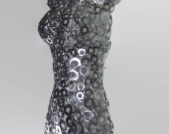 May include: A silver metal sculpture of a human torso made entirely of small metal washers.