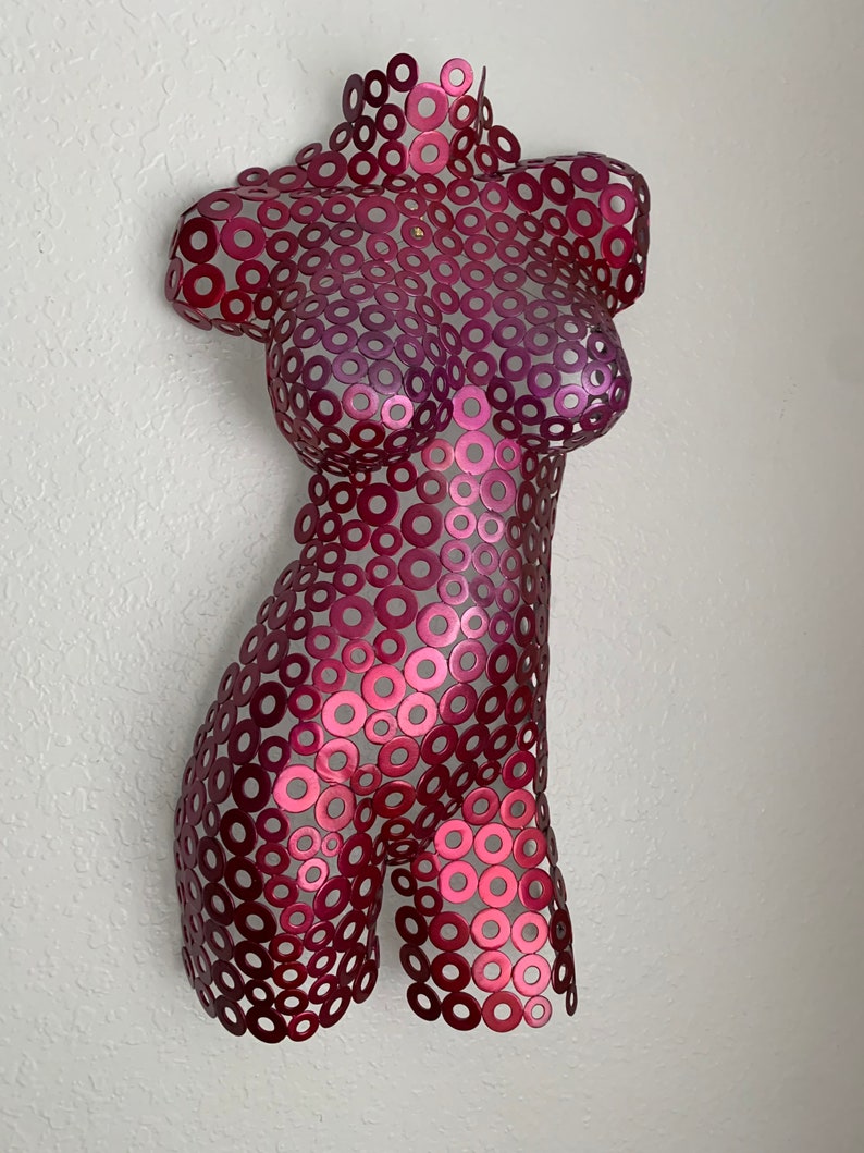 May include: A metal sculpture of a human torso made of small, overlapping circles. The sculpture is painted in shades of pink and red.