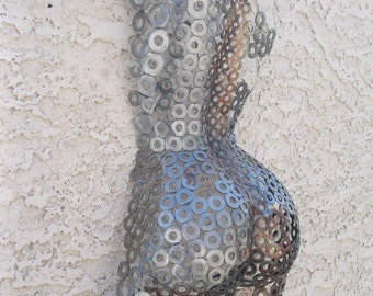 May include: A metal sculpture of a human torso made from hundreds of silver washers. The sculpture is mounted on a white wall.