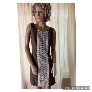 May include: A brown sleeveless dress with a white lace panel down the front.