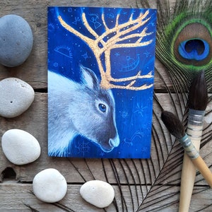 La carte de voeux Renne Shaman par Hannah Willow. Mettant en vedette un renne aux bois dorés