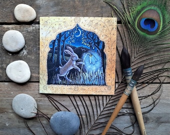 The Harebell Lantern Greetings Card by Hannah Willow. Featuring a Hare Playing With a Bright Bluebell.