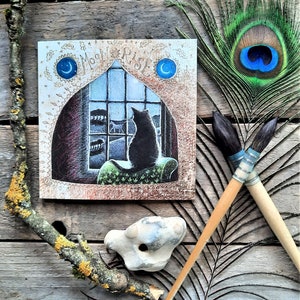 Carte de voeux « Moon Rise » par Hannah Willow. Mettant en vedette un chat observant le monde nocturne par la fenêtre.