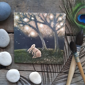 Die Magic Tree Grußkarte von Hannah Willow. Mit einem Hasen, der einen Baum voller Lichter betrachtet.