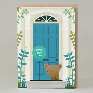 Puede incluir: Tarjeta de felicitación con una puerta turquesa y un oso pardo. La puerta tiene un globo verde con el texto "LOVE YOU DAD". La tarjeta tiene un borde beige y está decorada con ilustraciones de plantas verdes y azules.
