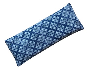 May include: A rectangular, patterned pillow with a blue and white floral design. The pillow is approximately 18 inches long and 6 inches wide. The fabric has a repeating pattern of stylized flowers.