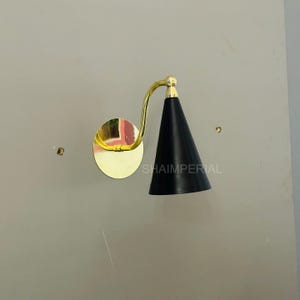 May include: A white ceramic mug with a black handle and the text "But First, Coffee" in a black, bold font. The mug is sitting on a white surface. The mug is approximately 4 inches tall.