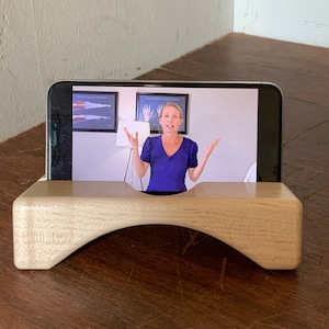 Wooden iPhone stand supports iPhone in landscape.