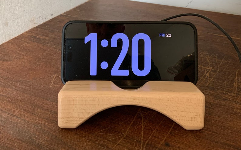 Wooden iPhone stand with iPhone in Standby.