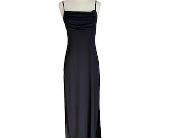 May include: A black maxi dress with thin straps and a gathered neckline. The dress has a fitted bodice and a flowing skirt with side slits.