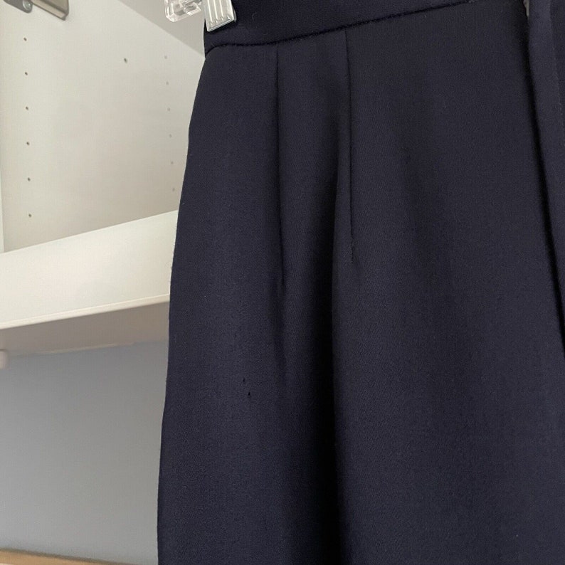 K&ouml;nnte beinhalten: Eine dunkelblaue, hochgeschnittene Hose aus glattem, strukturiertem Stoff.