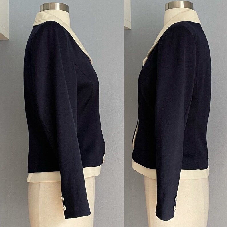K&ouml;nnte beinhalten: Ein marineblauer Blazer mit wei&szlig;em Kragen und Manschetten. Der Blazer hat eine figurbetonte Silhouette und lange &Auml;rmel.