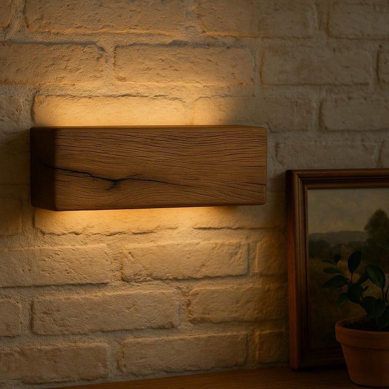 Peut inclure: Applique murale rectangulaire en bois clair, d&eacute;gageant une lumi&egrave;re chaleureuse. Fix&eacute;e sur un mur de briques blanches, la lumi&egrave;re se diffuse vers le bas, cr&eacute;ant une ambiance cosy et accueillante.