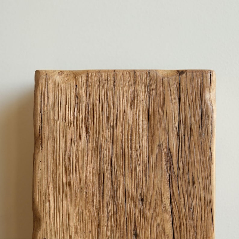 May include: Close-up of a rustic wooden plank with a natural, weathered finish. The wood has a warm brown color and shows signs of age and use.
