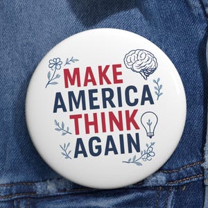 May include: A white button with the text "MAKE AMERICA THINK AGAIN" in red and navy blue, with a brain, lightbulb, and floral illustrations. The button is pinned to a blue denim jacket.