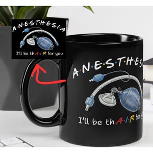 Könnte beinhalten: Schwarze Keramiktasse mit dem Wort "ANESTHESIA" in weißen Buchstaben. Die Tasse zeigt eine medizinische Illustration einer Anästhesiemaschine und den Satz "I'll be th A-I-R for you".