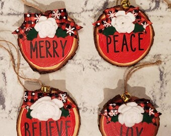 Set of 4 wood slice ornaments painted red with the words Peace, Joy, Merry and Believe in black handmade felt flower and buffalo check bow.