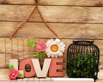 Love Sign felt flowers wall decor gold wire frame pink and white flowers and wood love in center hangs from braided twine