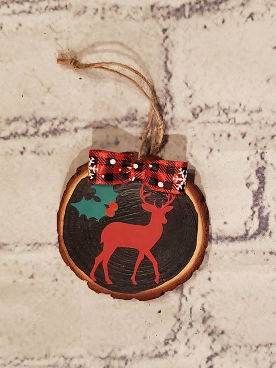 3 in. round wood slice ornament painted black with a buffalo check bow and a red deer with green holly name and year added for FREE.