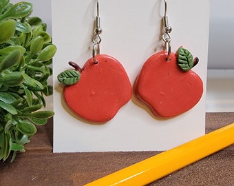 Cute red apple polymer clay handmade dangle  earrings with a green leaf and a brown stem. Perfect for Fall or teachers