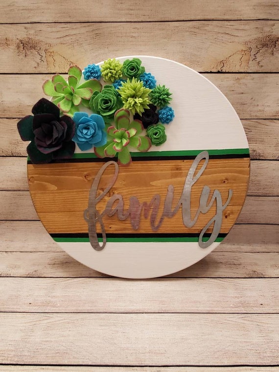 18 in. Round wood sign with galvanized metal "Family" With handmade felt succulents and painted white with green stripe and stained center.
