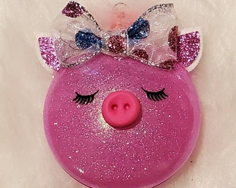 Cute little piggy ornament is shatterproof and pink glittery on the inside with faux leather ears and a glittered polka dot bow clay snout.