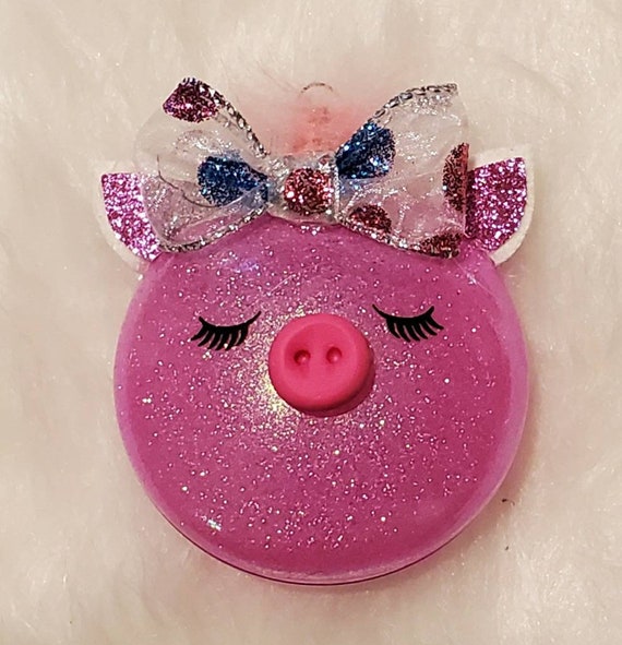 Cute little piggy ornament is shatterproof and pink glittery on the inside with faux leather ears and a glittered polka dot bow clay snout.