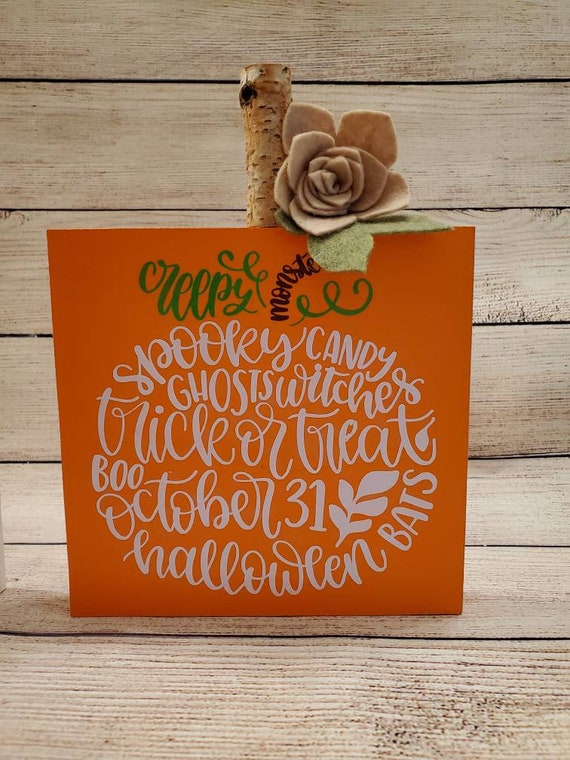 Rustic pumpkin shelf sitting sign with handmade felt flowers , a birch wood stem and pumpkin word art design. 6 in. wide 8 in. tall.