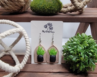 Cute black potted plant on a tan framed background.  Surgical steel dangle earring style of choice. Unique and one of a kind and lightweight