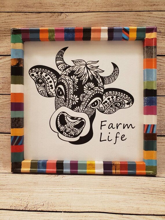 Cow mandala canvas wall decor framed with wood wrapped in Hand torn recycled magazine. 12×12 inch One of a kind ready to go.