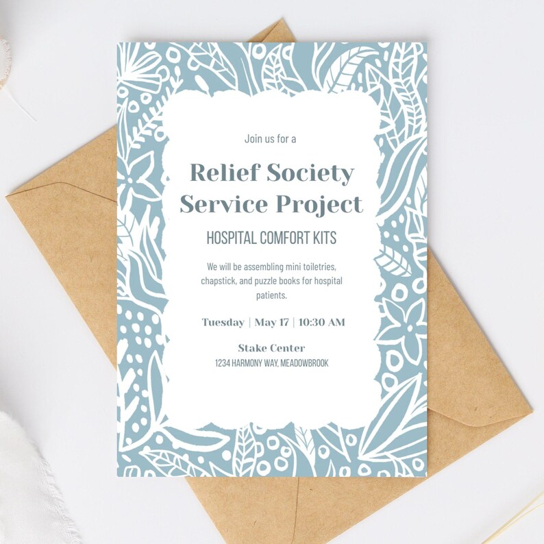 May include: An invitation for a Relief Society Service Project, Hospital Comfort Kits. The invitation has a light blue floral design with white accents. The text includes the date, time, and location of the event. The invitation is placed on a brown envelope.