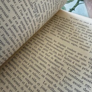 Puede incluir: Libro abierto con texto en franc&eacute;s, con p&aacute;ginas envejecidas y amarillentas. El texto est&aacute; en una fuente serif, con sangrado de tinta visible. El libro est&aacute; abierto para revelar dos p&aacute;ginas enfrentadas, con el texto llenando las p&aacute;ginas.